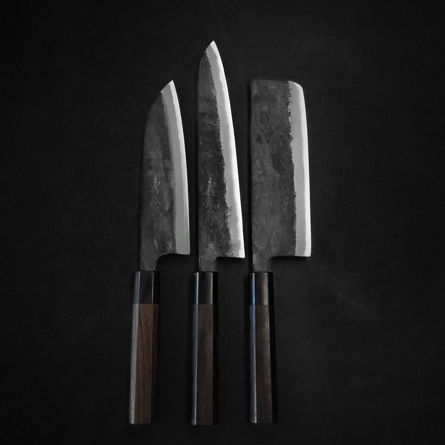 Top view of three kurouchi knives from Yoshihiro namely santoku, gyuto, and nakiri.