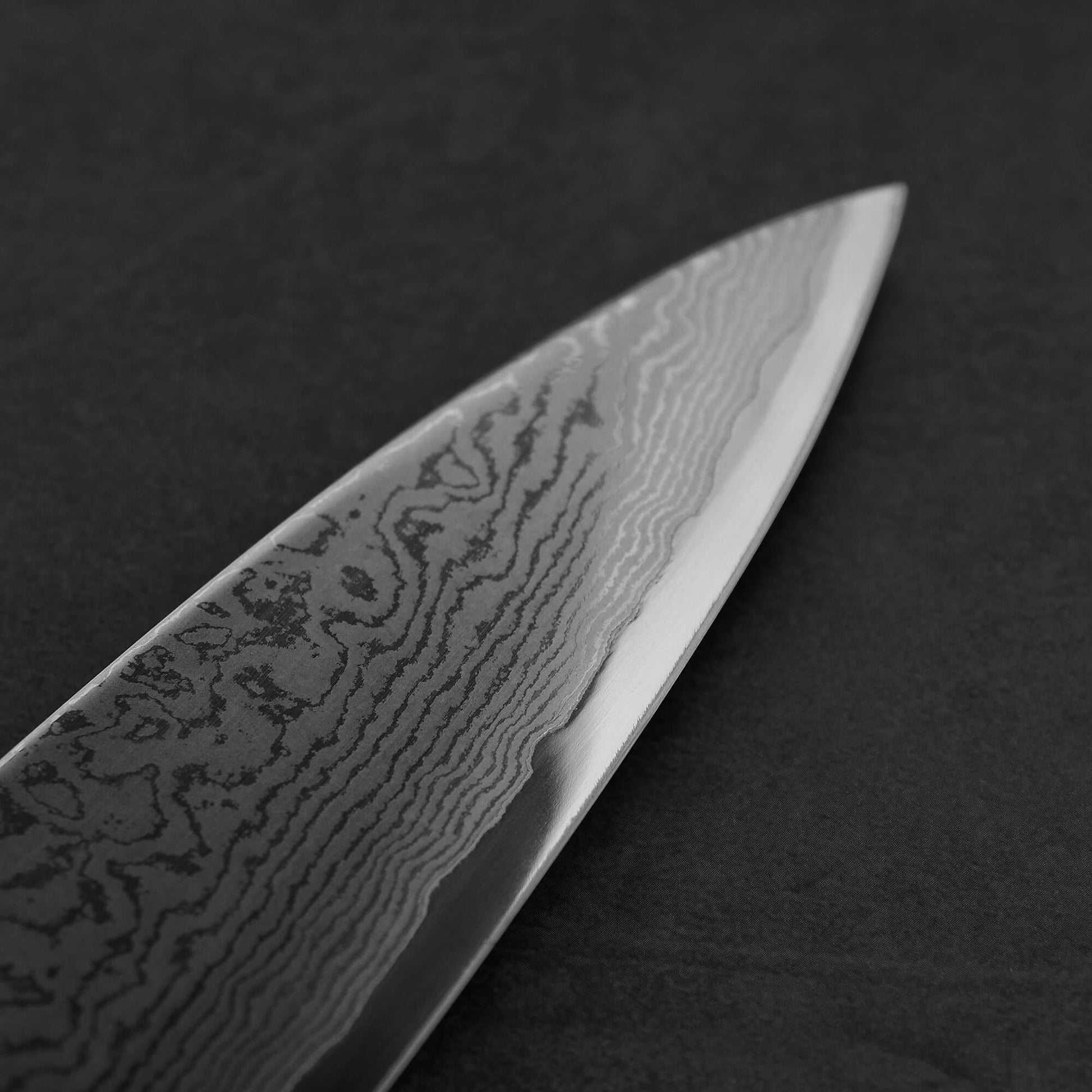 Close up view of the tip area of Sukenari damascus XEOS gyuto . Image shows the right side of the blade