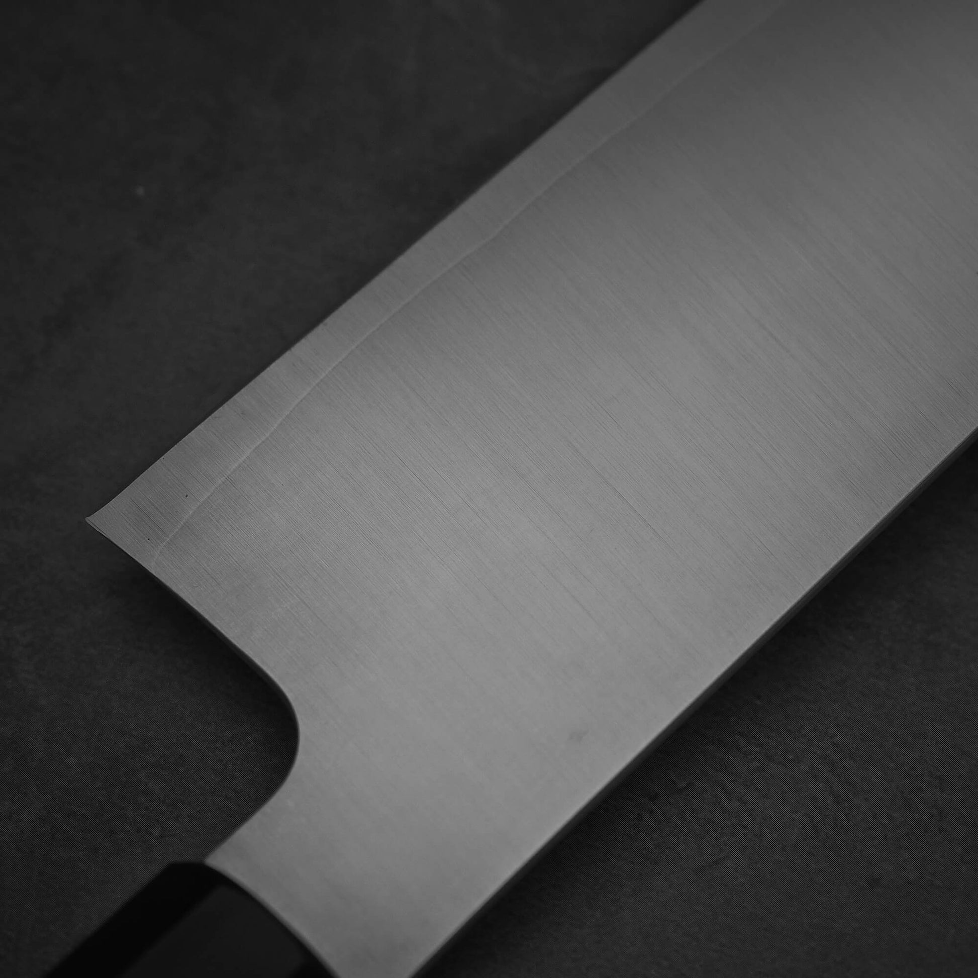 Close up view of Sukenari XEOS gyuto 240mm. Image shows the back side of the knife