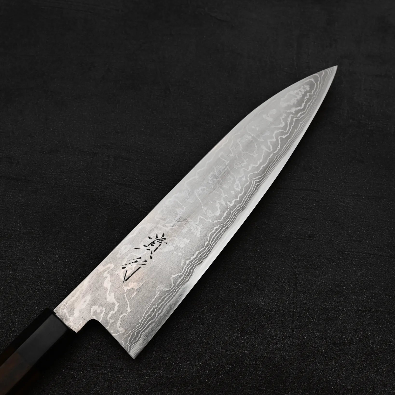 Close up view of the balde of Takayuki Iwai aogami#2 damascus 210mm gyuto knife