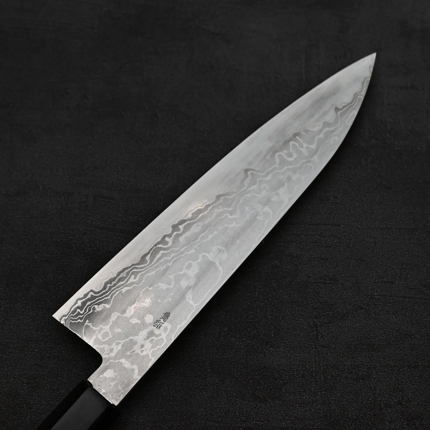 Close up view of the blade of Takayuki Iwai aogami#2 damascus 210mm gyuto knife showing the back side