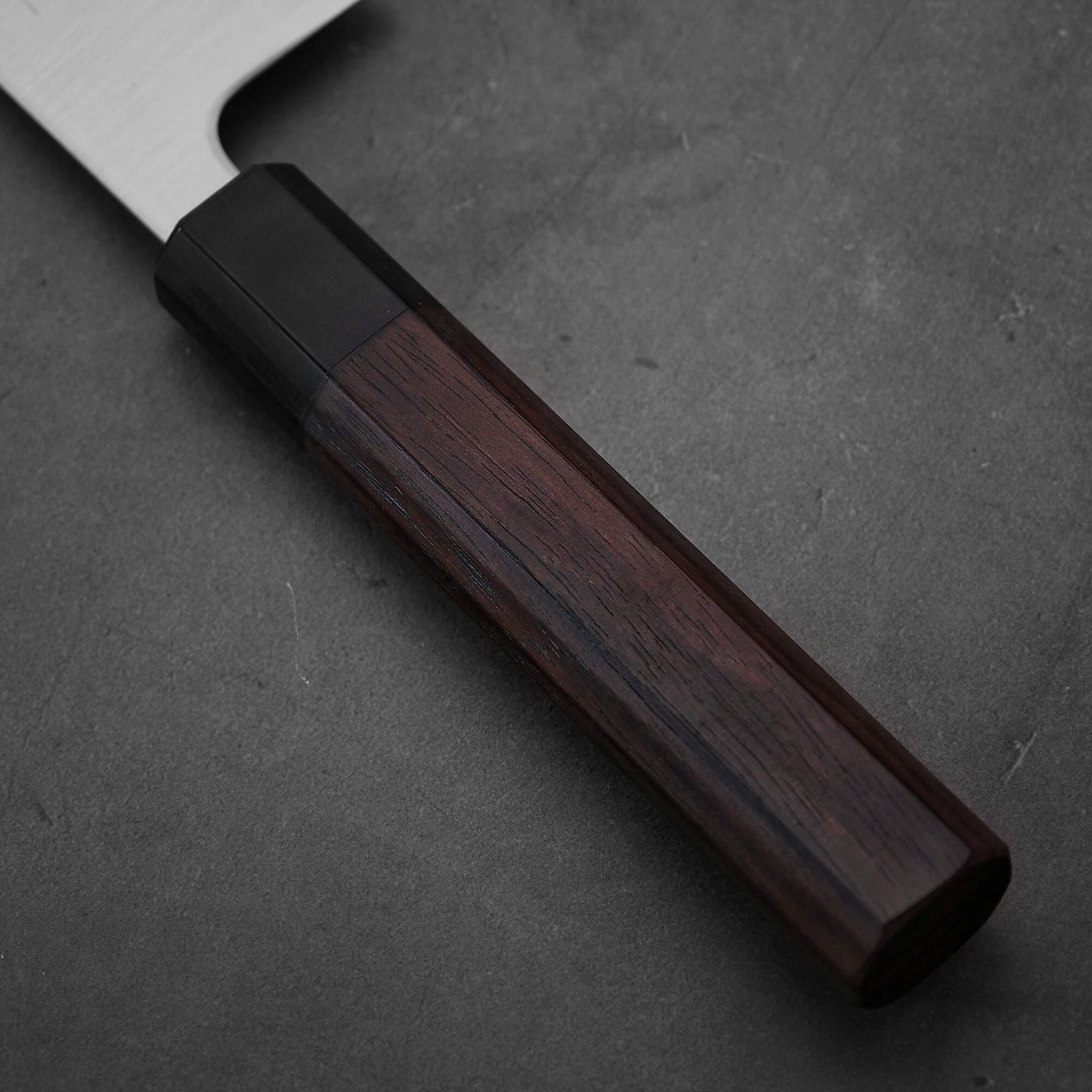 Close up view of the handle of Yoshihiro migaki aogami super gyuto. This Japanese chef's knife has an octagonal rosewood handle.