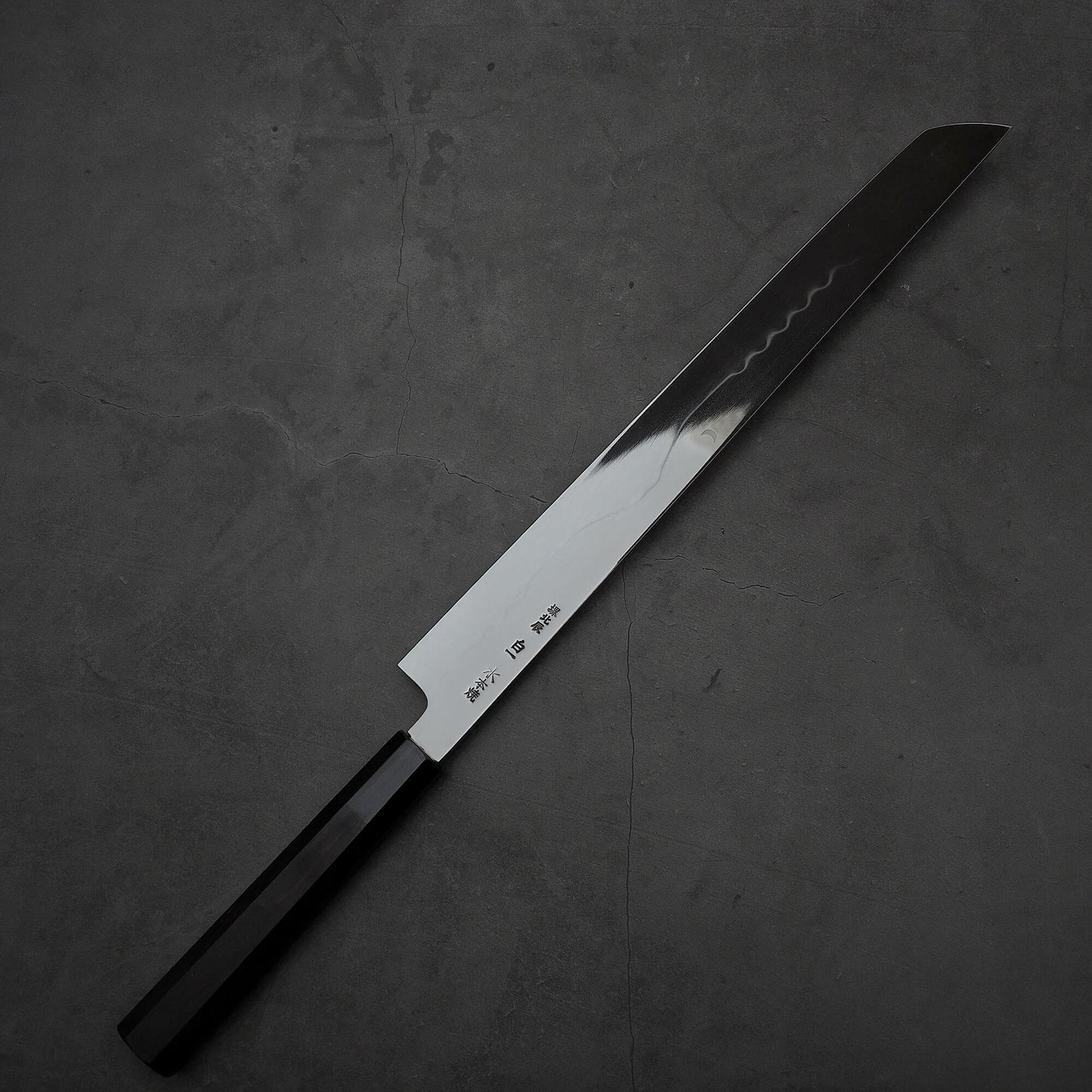 Top down view of the back side of Yoshikazu Ikeda honyaki sakimaru takohiki. This hand-forged Japanese knife is made of shirogami#1 steel.