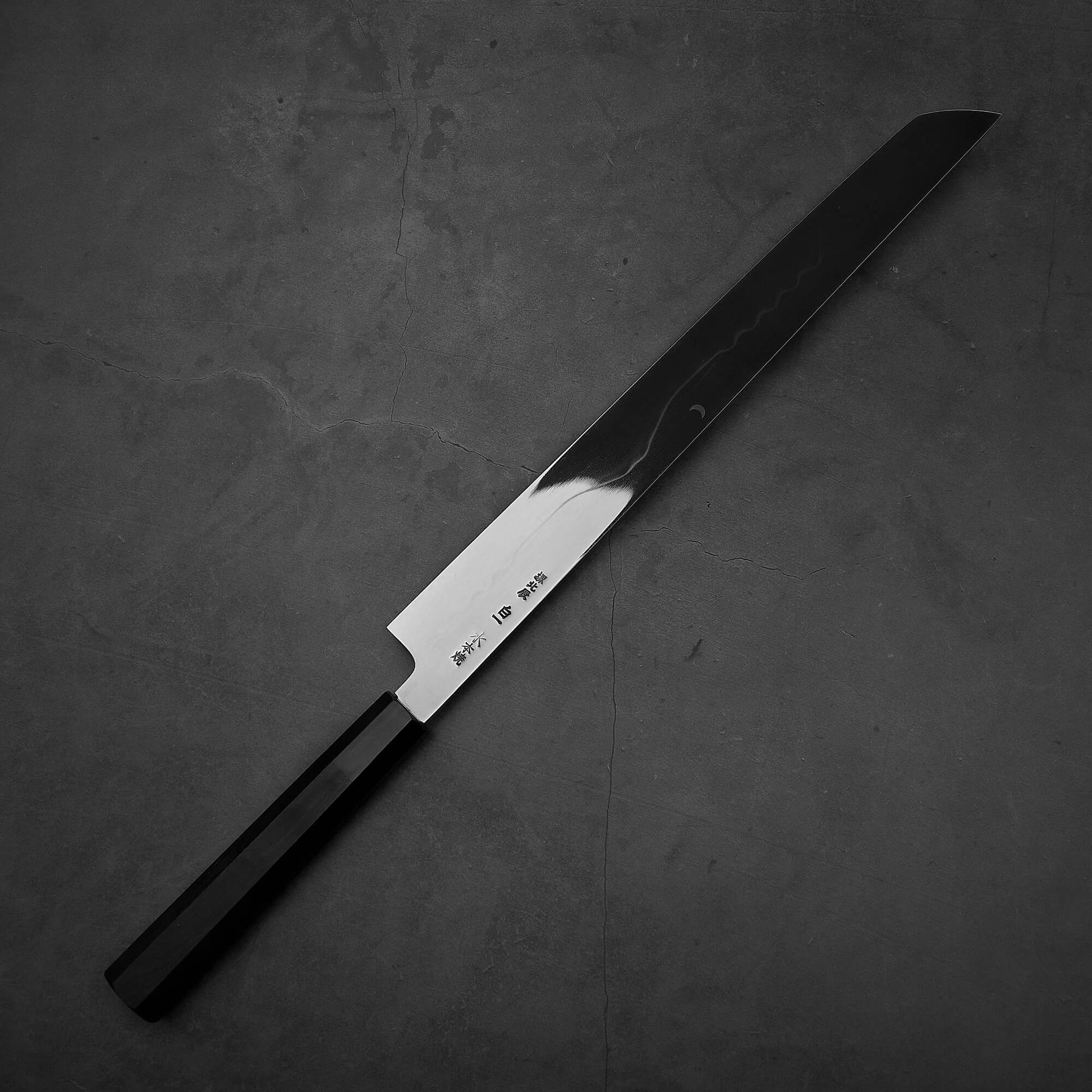 Top down view of the backside of Yoshikazu Ikeda honyaki sakimaru takohiki. This hand-forged Japanese knife is made of shirogami#1 steel.