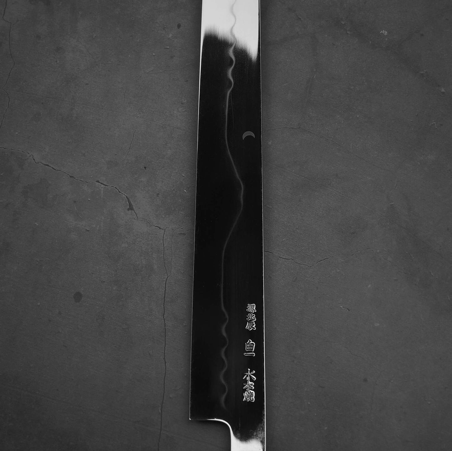 Close up view of the kanji of Yoshikazu Ikeda honyaki sakimaru takohiki. This hand-forged Japanese knife is made of shirogami#1 steel.