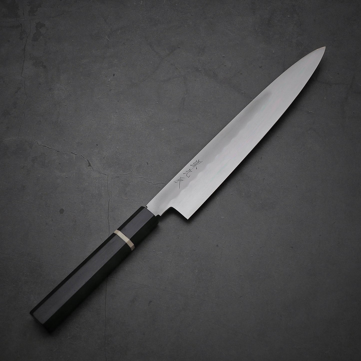 Top down view of Yoshikazu Ikeda honyaki sujihiki. This hand-forged Japanese knife is made of shirogami#3 steel.
