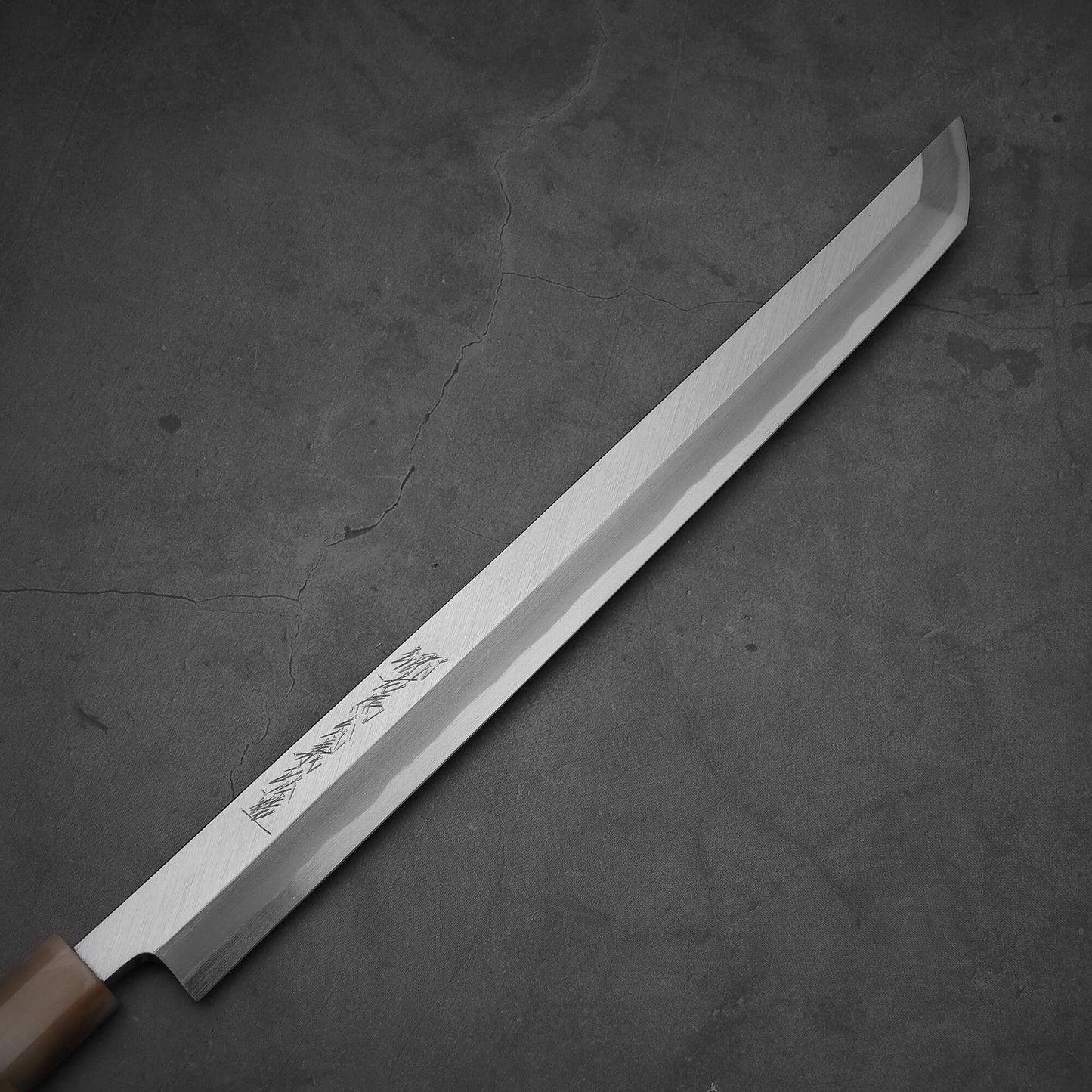 Close up view of the Yoshikazu Tanaka 300mm sakimaru takohiki knife with a hand-forged blade made of shirogami#2 steel.