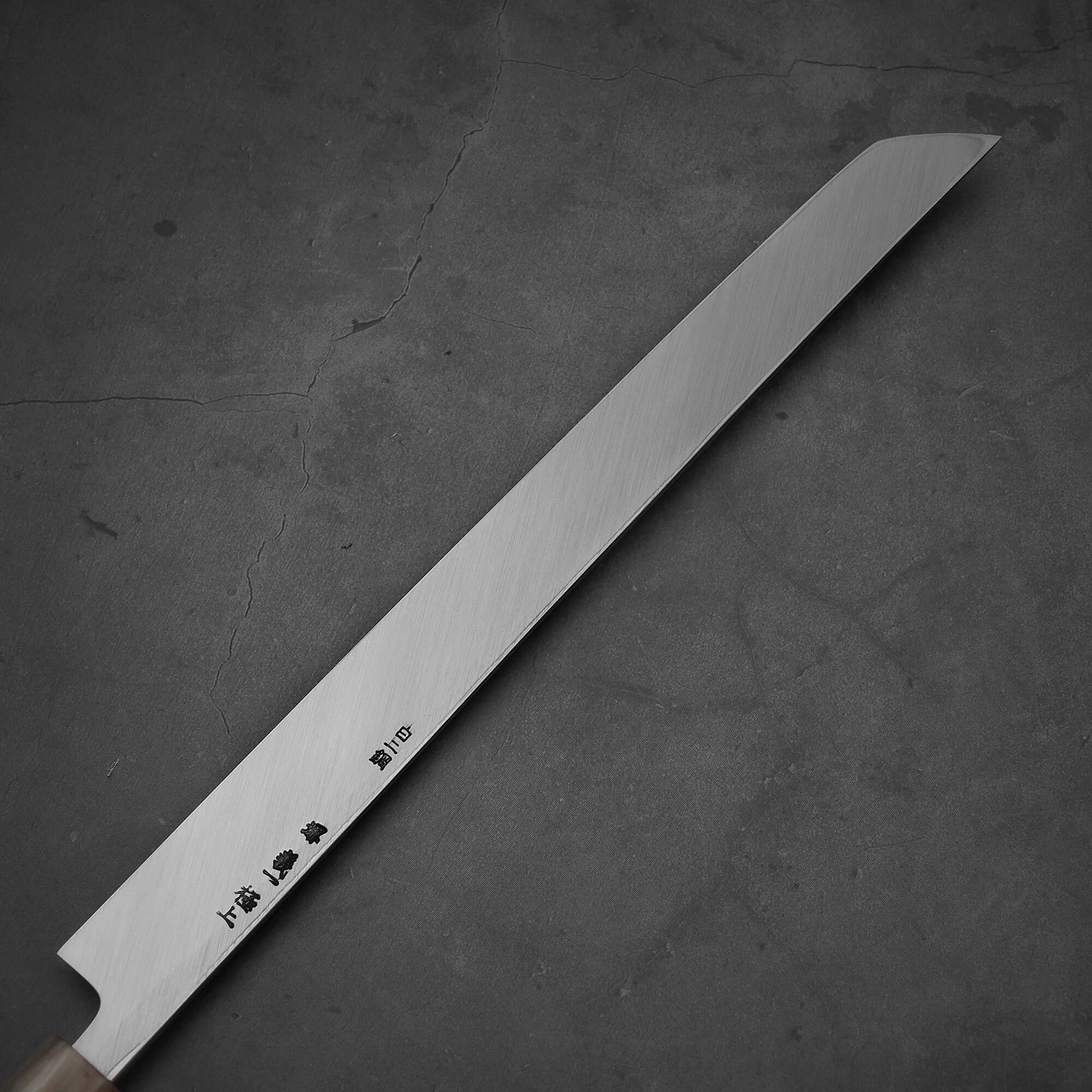Close up view of the Yoshikazu Tanaka 300mm sakimaru takohiki knife with a hand-forged blade made of shirogami#2 steel. Image shows back side of the knife