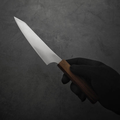 Hand holding a Yu Kurosaki HAP40 Gekko petty knife. Image shows the left side of the knife.