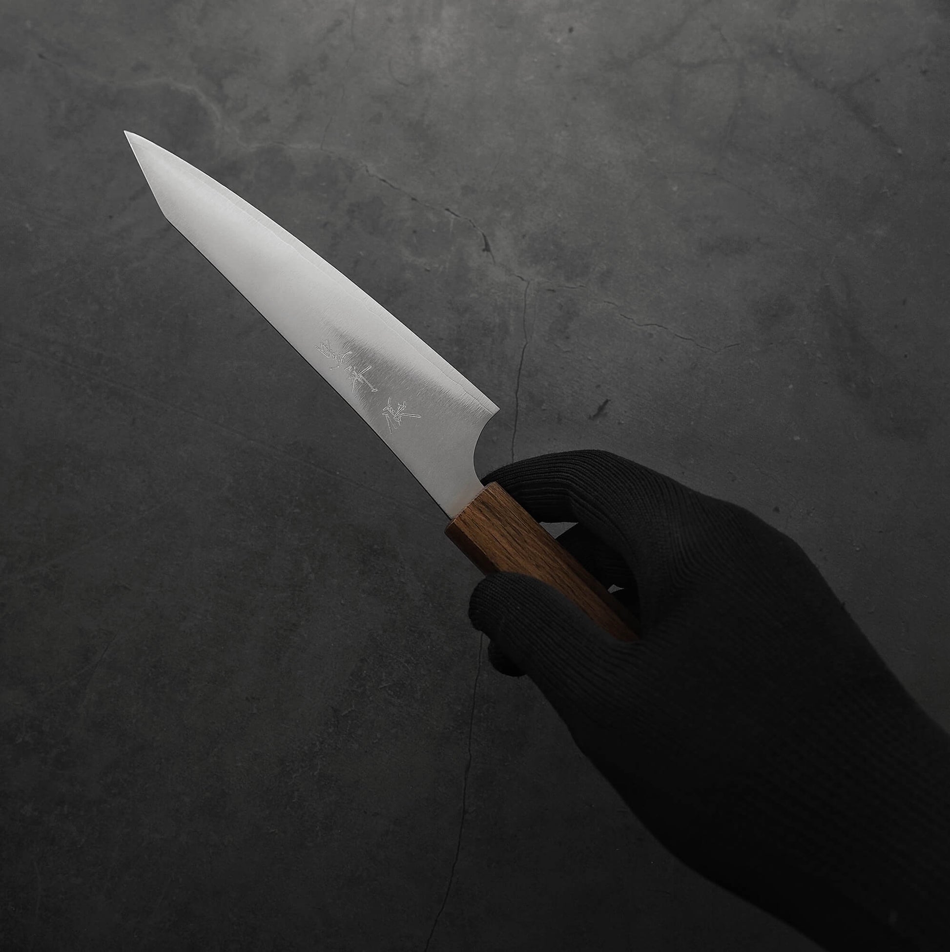 Hand holding a Yu Kurosaki HAP40 Gekko petty knife. Image shows the right side of the knife.