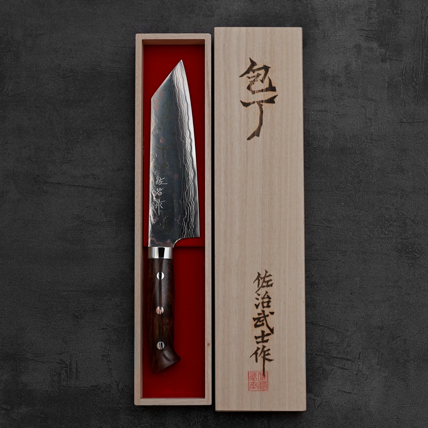 Top down view of Takeshi Saji rainbow damascus aogami#2 bunka knife inside its box