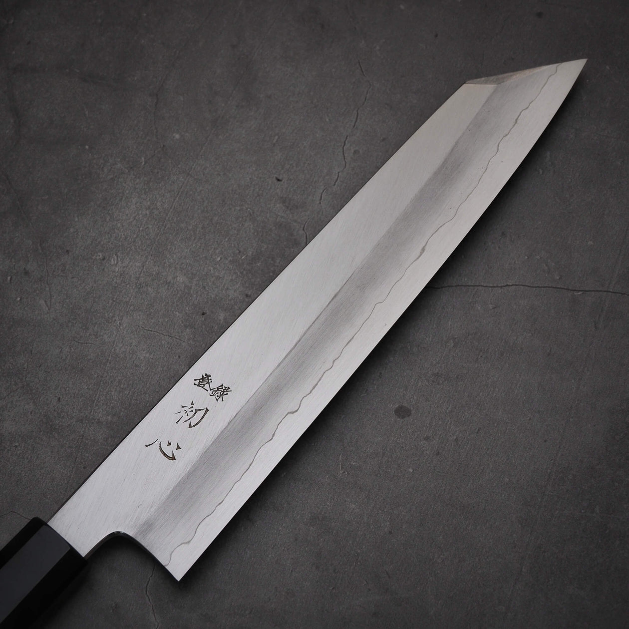 Close up view of the blade of Hatsukokoro Nakagawa ginsan kiritsuke gyuto knife. Image shows front side of the blade
