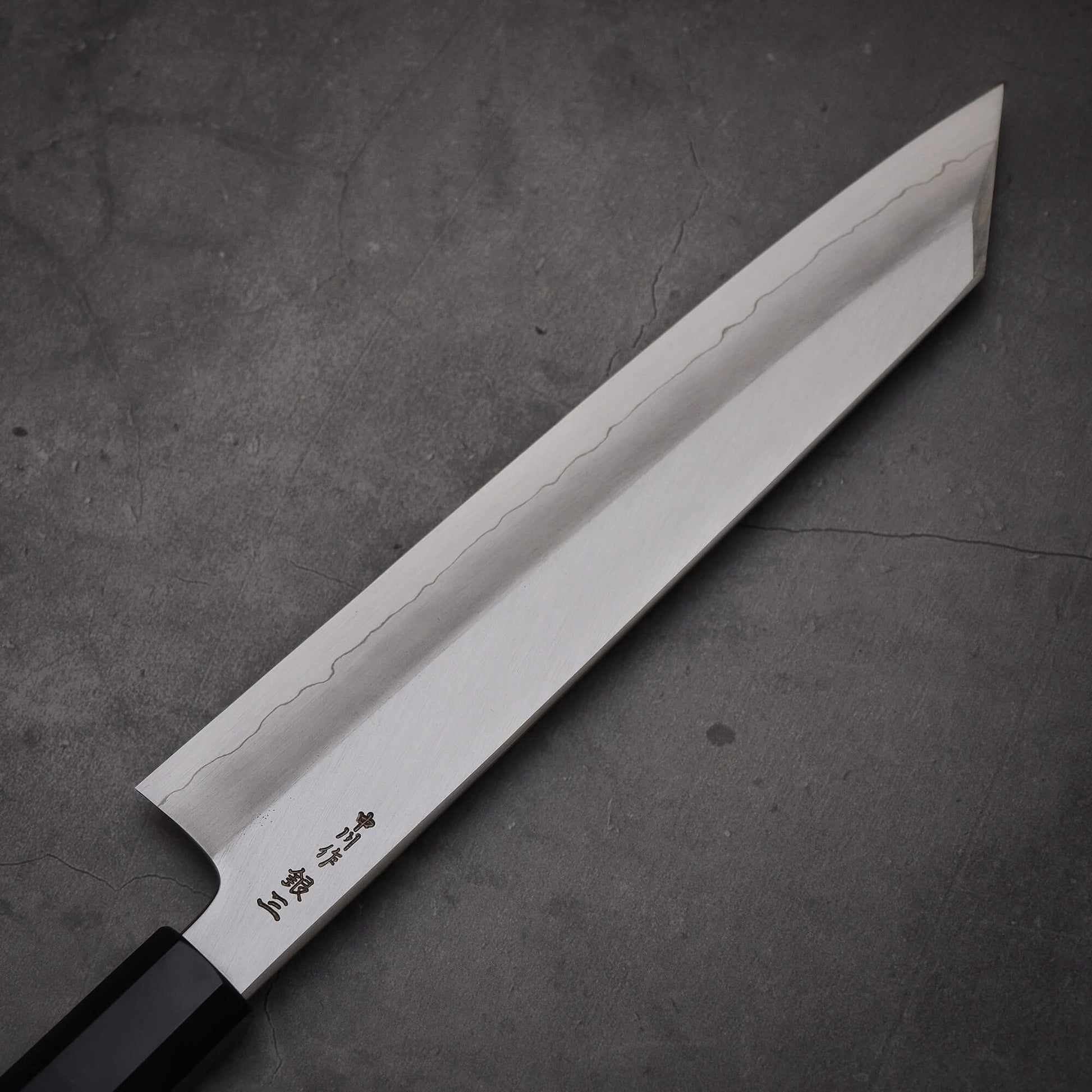 Close up view of the blade of Hatsukokoro Nakagawa ginsan kiritsuke gyuto knife. Image shows left side of the blade