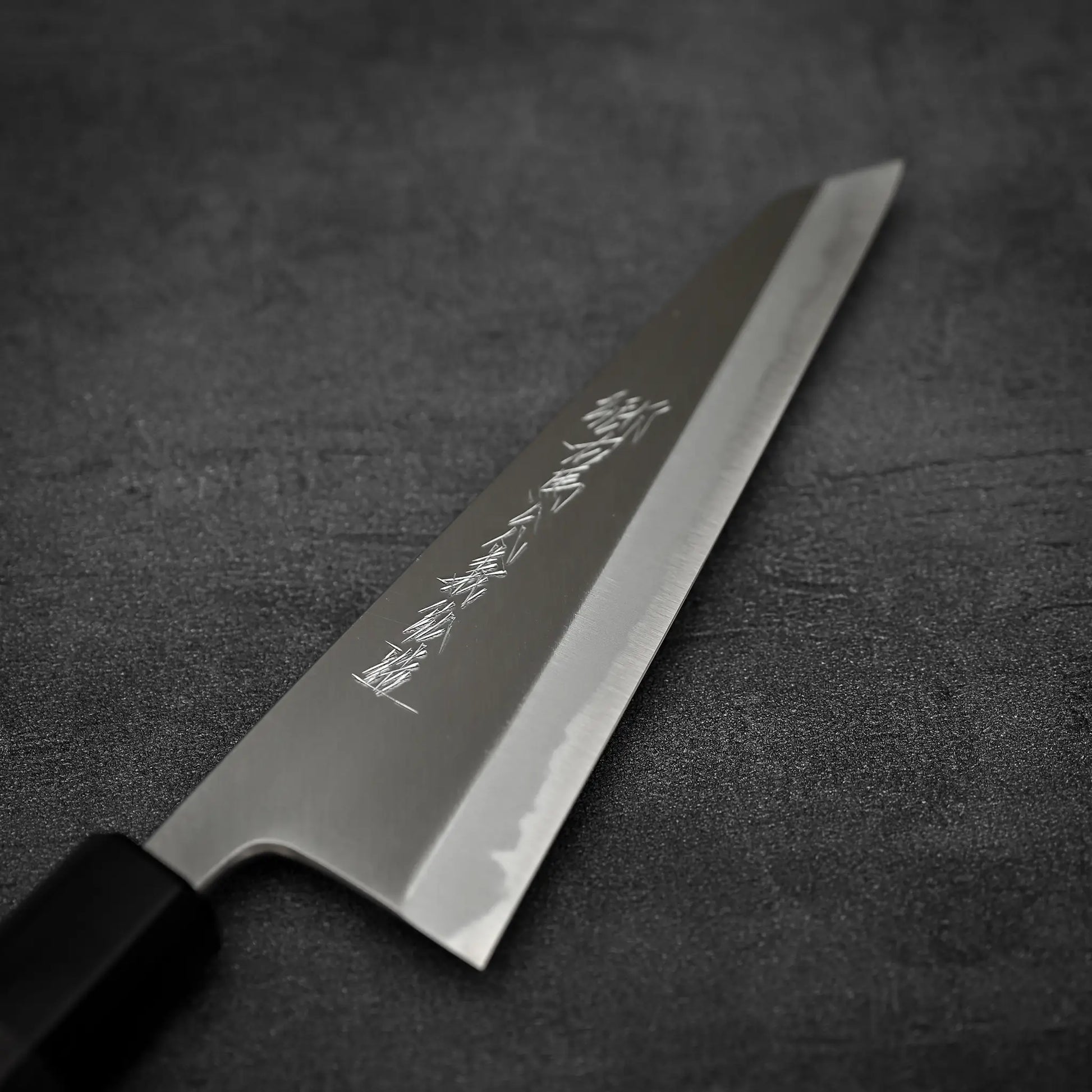 Angled view of the front blade of Yoshikazu Tanaka shirogami#1 double bevel honesuki knife