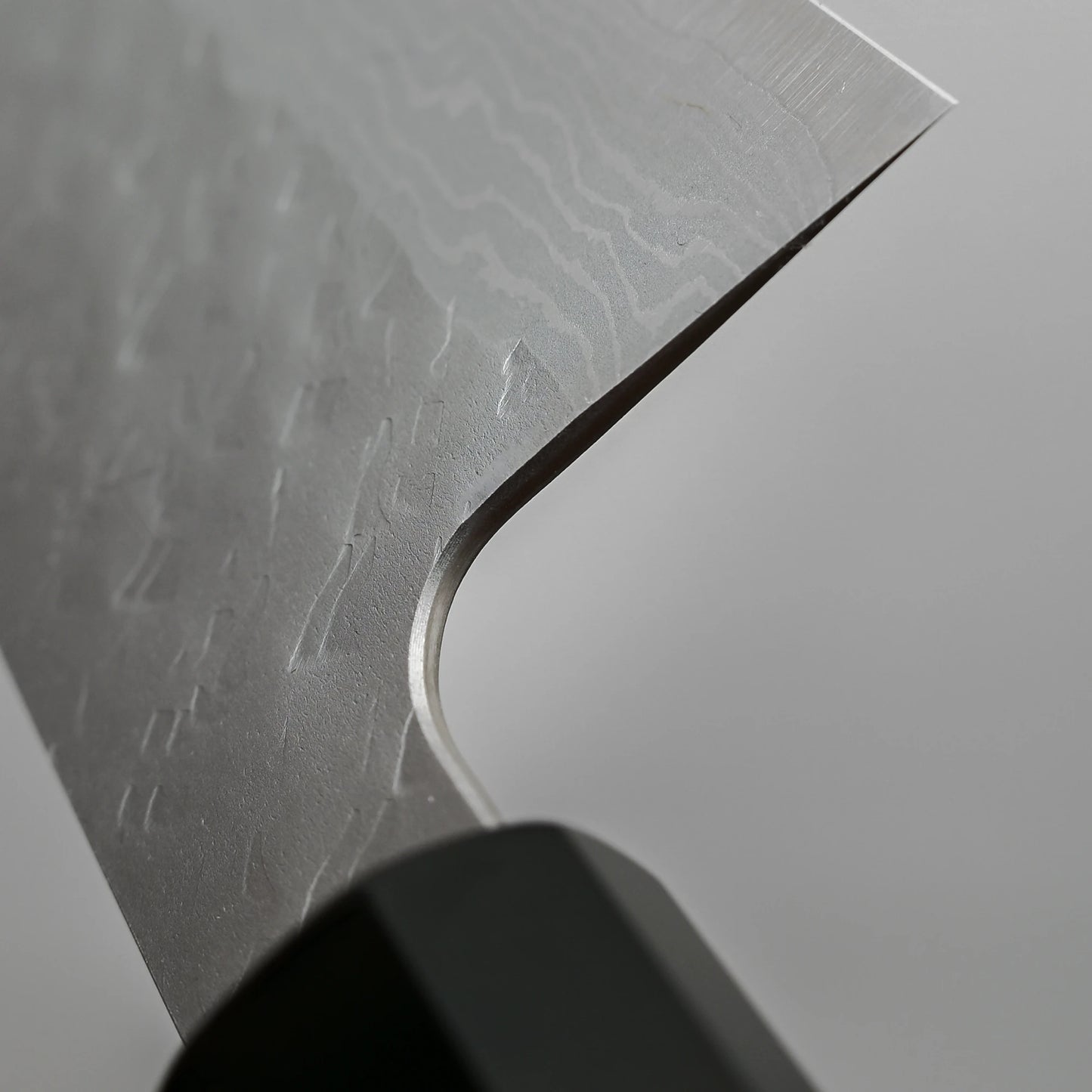 Close-up view of the choil of 240mm Nigara tsuchime damascus VG10 gyuto knife