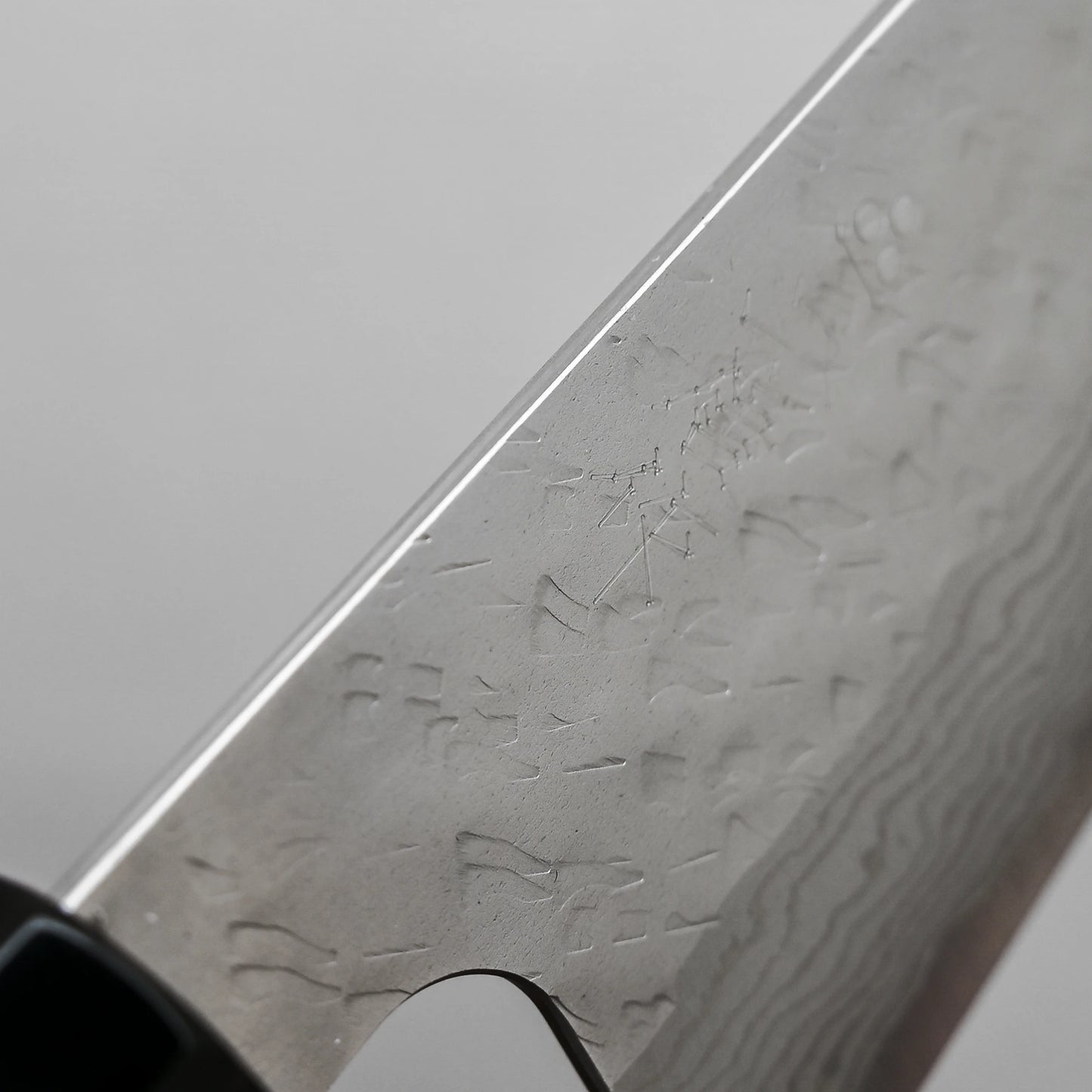 Close-up view of the spine of 240mm Nigara tsuchime damascus VG10 gyuto knife