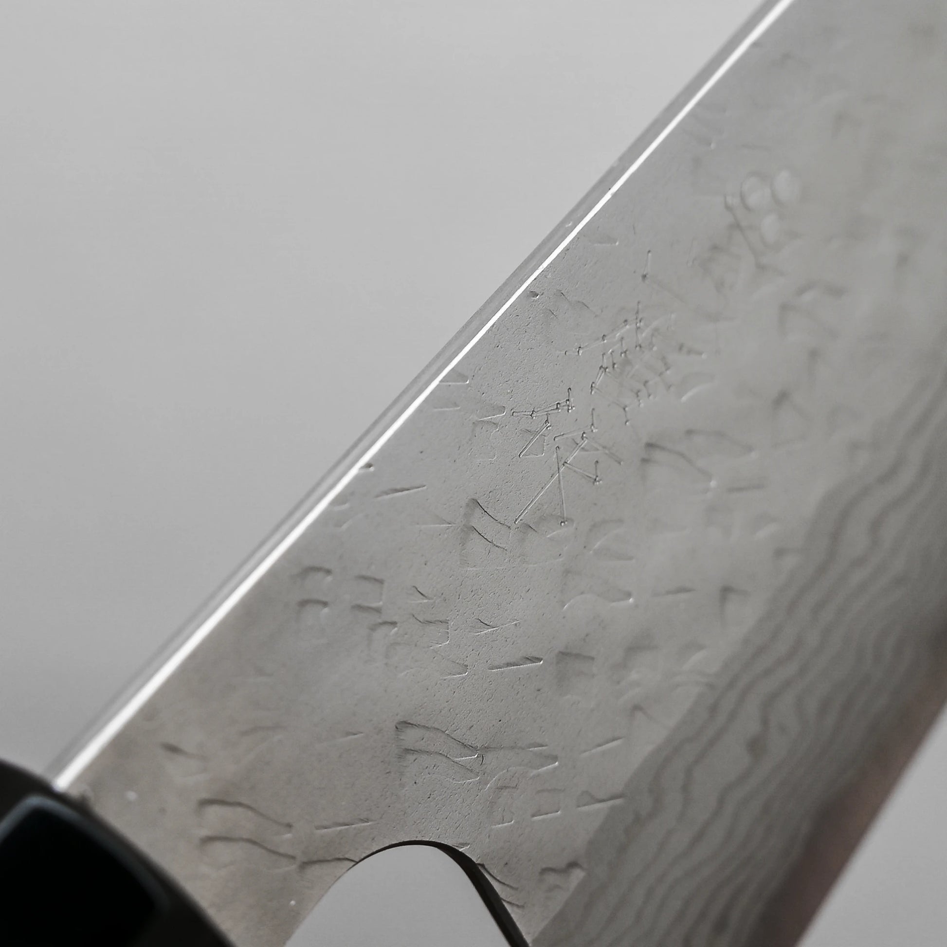 Close-up view of the spine of 240mm Nigara tsuchime damascus VG10 gyuto knife