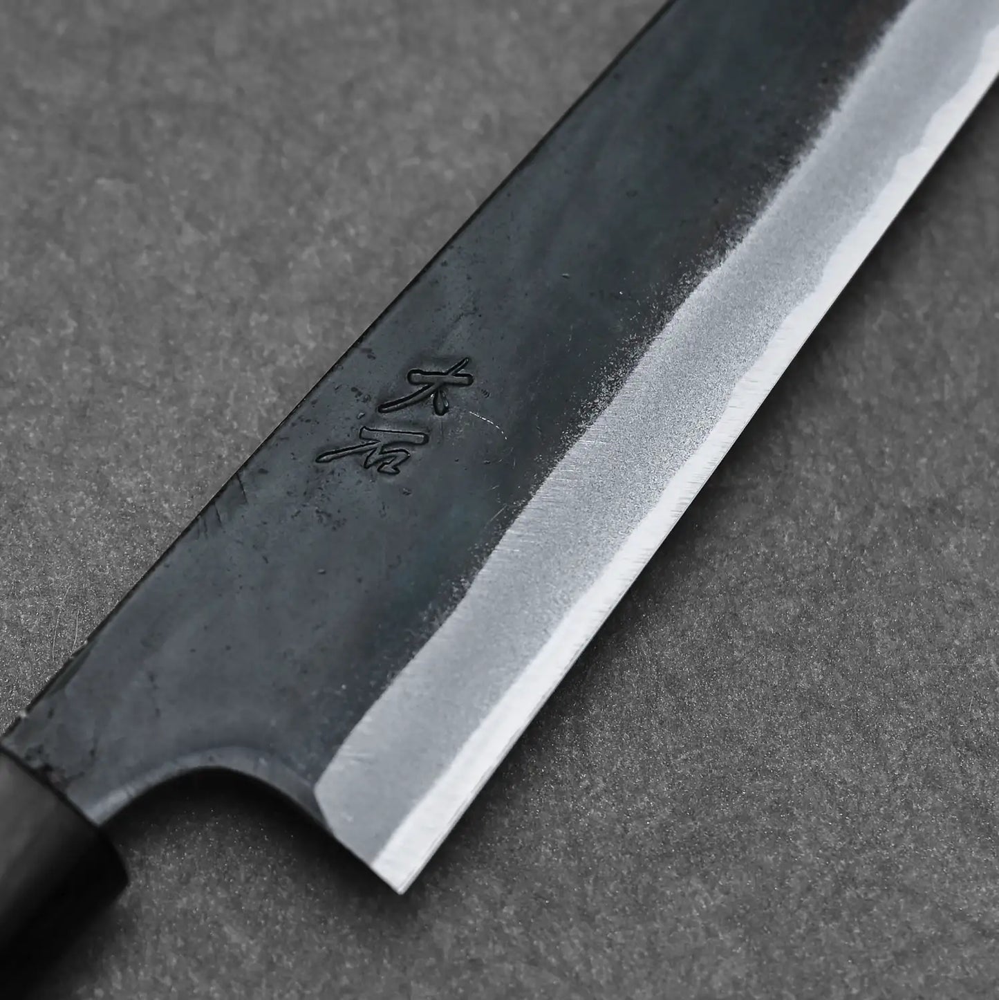 Detailed shot of the Ohishi blue#1 kitchen knife showing the maker's mark