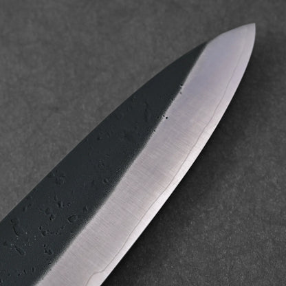 Close-up of the Ohishi kurouchi SLD gyuto 210mm chef knife blade by Ohishi on a dark textured background, showcasing its sharp edge and subtle metal patterns.