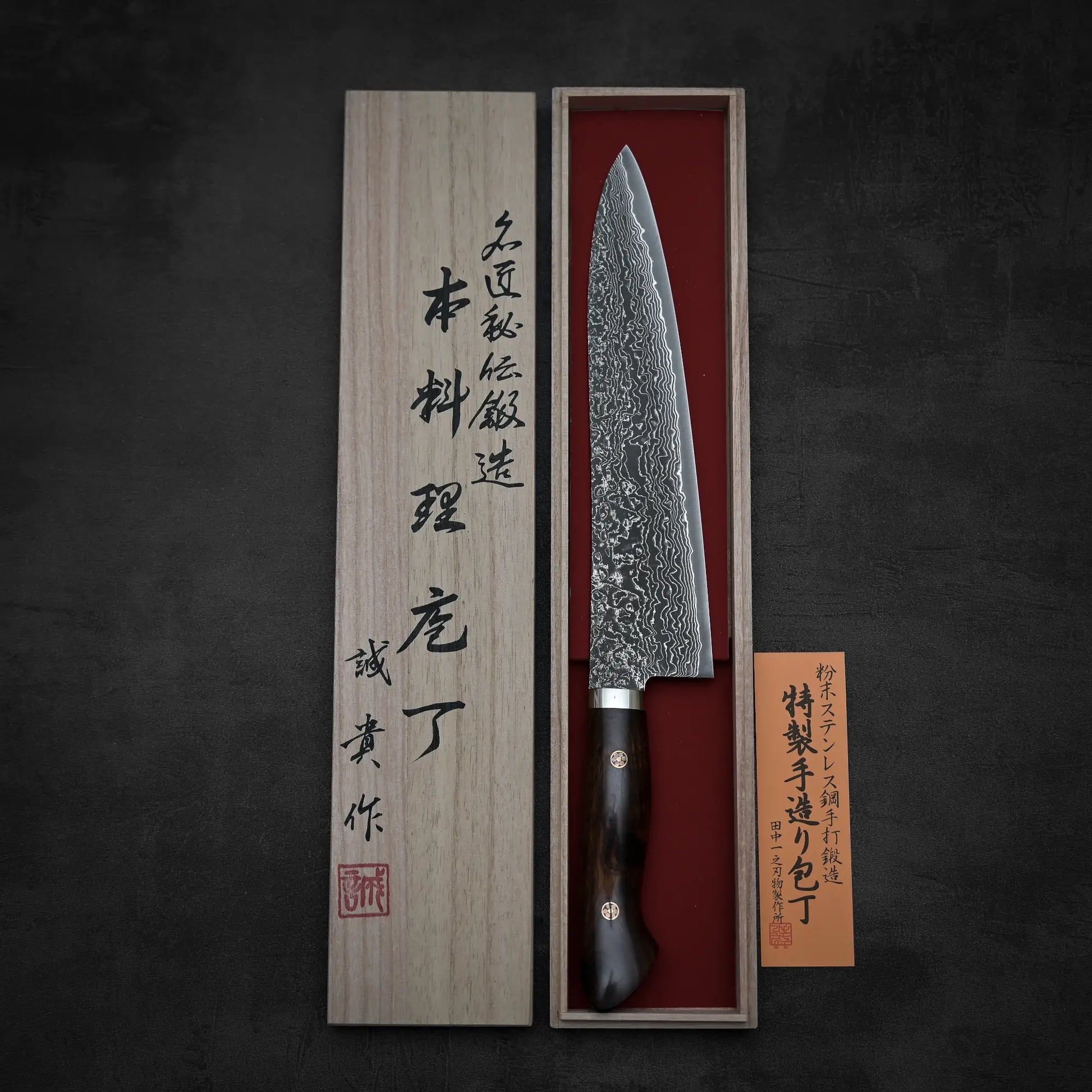 Top down view of 240mm Shigeki Tanaka R2 damascus ironwood gyuto knife with its kiri box