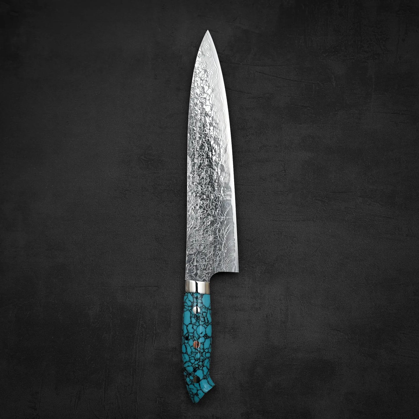 Top down view of Takeshi Saji R2 diamond damascus gyuto knife in vertical position