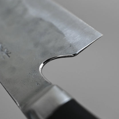 Close-up of the heel section of the Teruyasu Fujiwara Maboroshi shirogami#1 nakiri 165mm, featuring a polished spine and choil, visible finger notch, and part of the handle against a plain grey background.