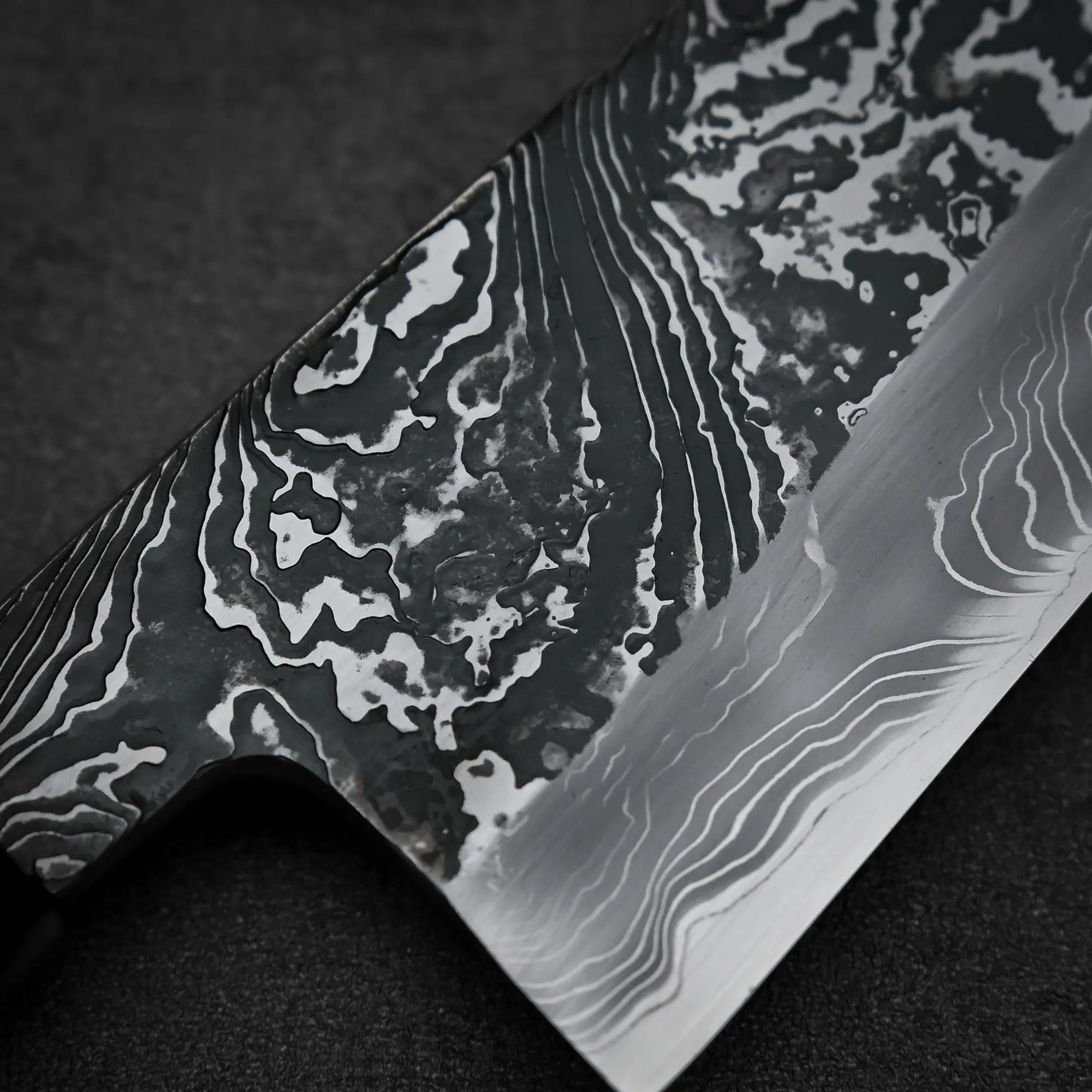 Macro shot of the front blade of Yoshihide Masuda shirogami#2 kurouchi damascus tall gyuto knife