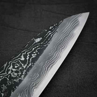 Macro shot of the tip area of Yoshihide Masuda shirogami#2 kurouchi damascus tall gyuto knife