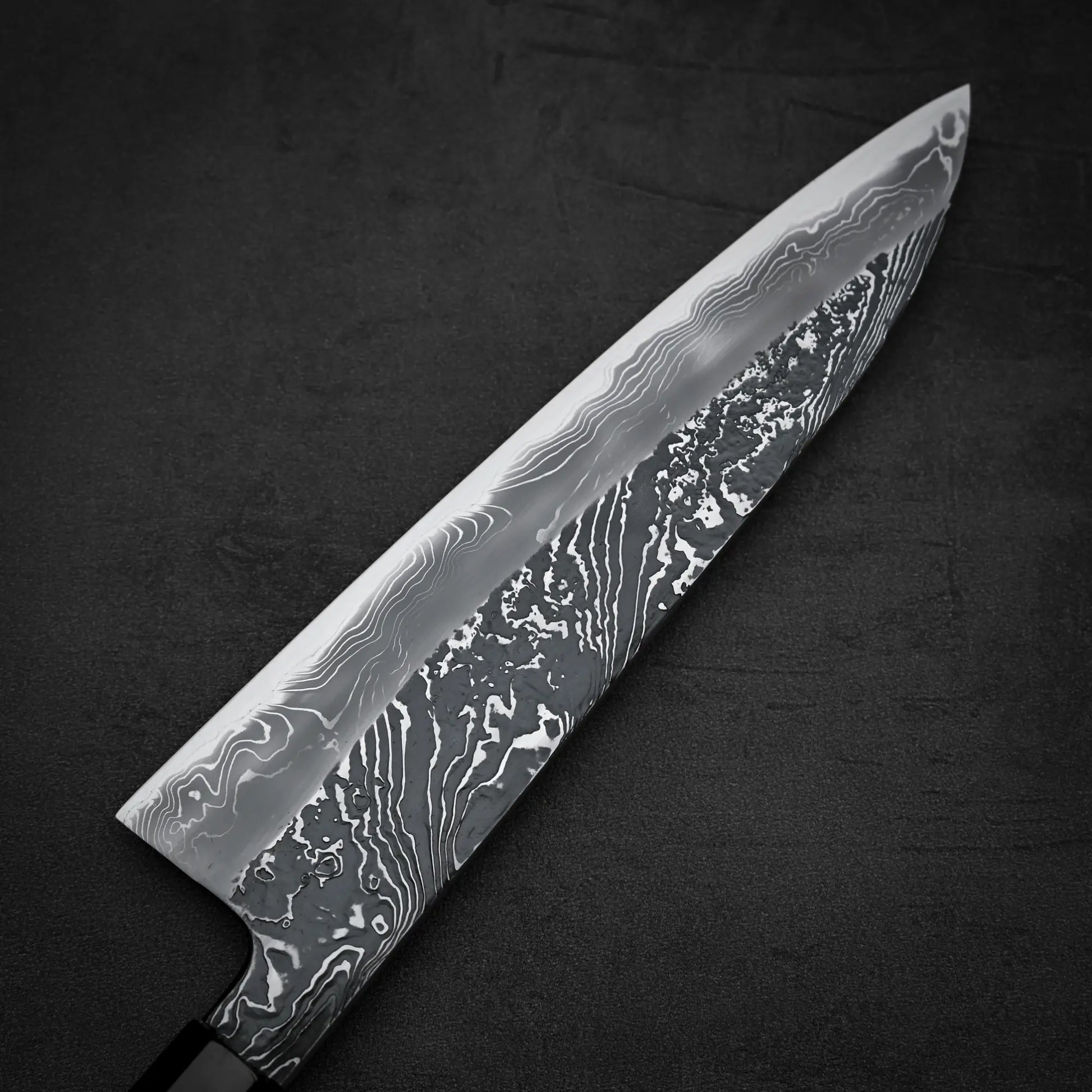 Close up view of the back side of Yoshihide Masuda shirogami#2 kurouchi damascus tall gyuto knife