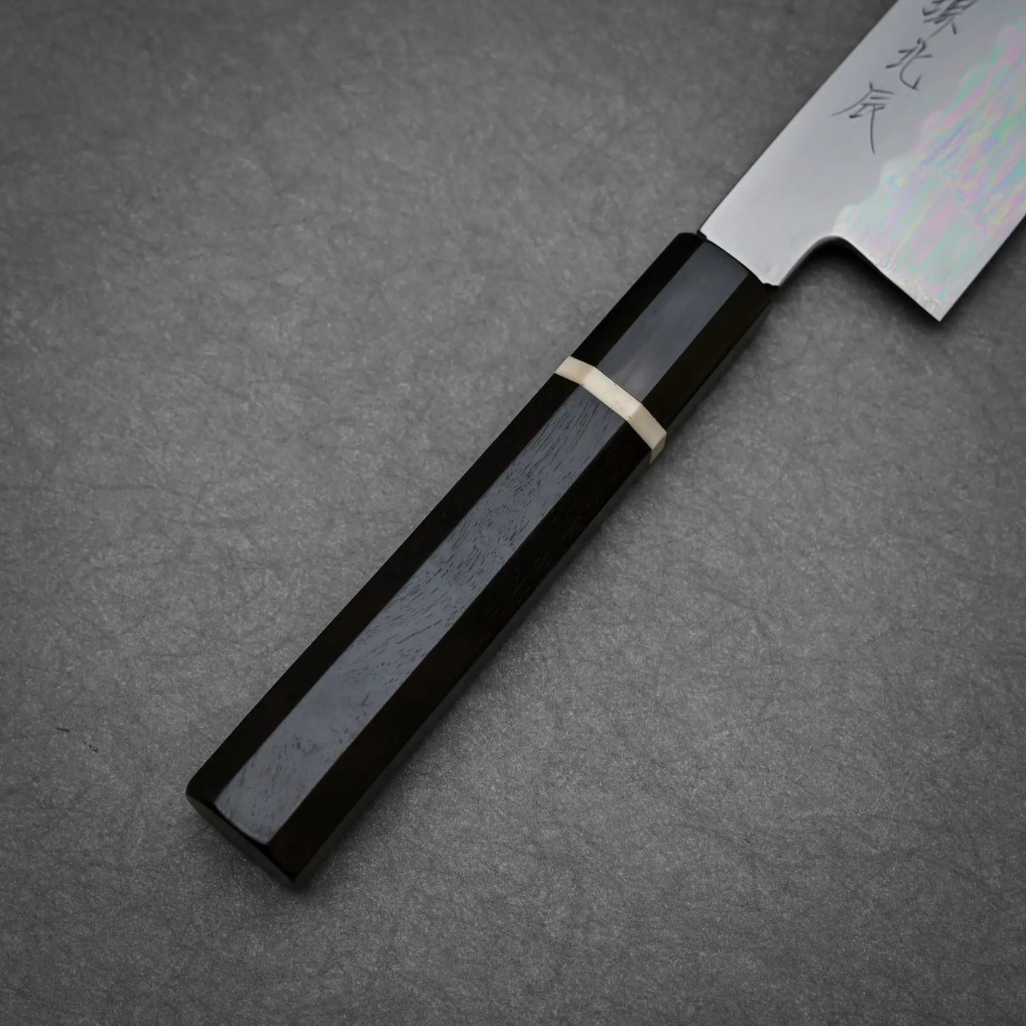 Close-up view of the ebony handle of 210mm Yoshikazu Ikeda shirogami#3 honyaki gyuto knife