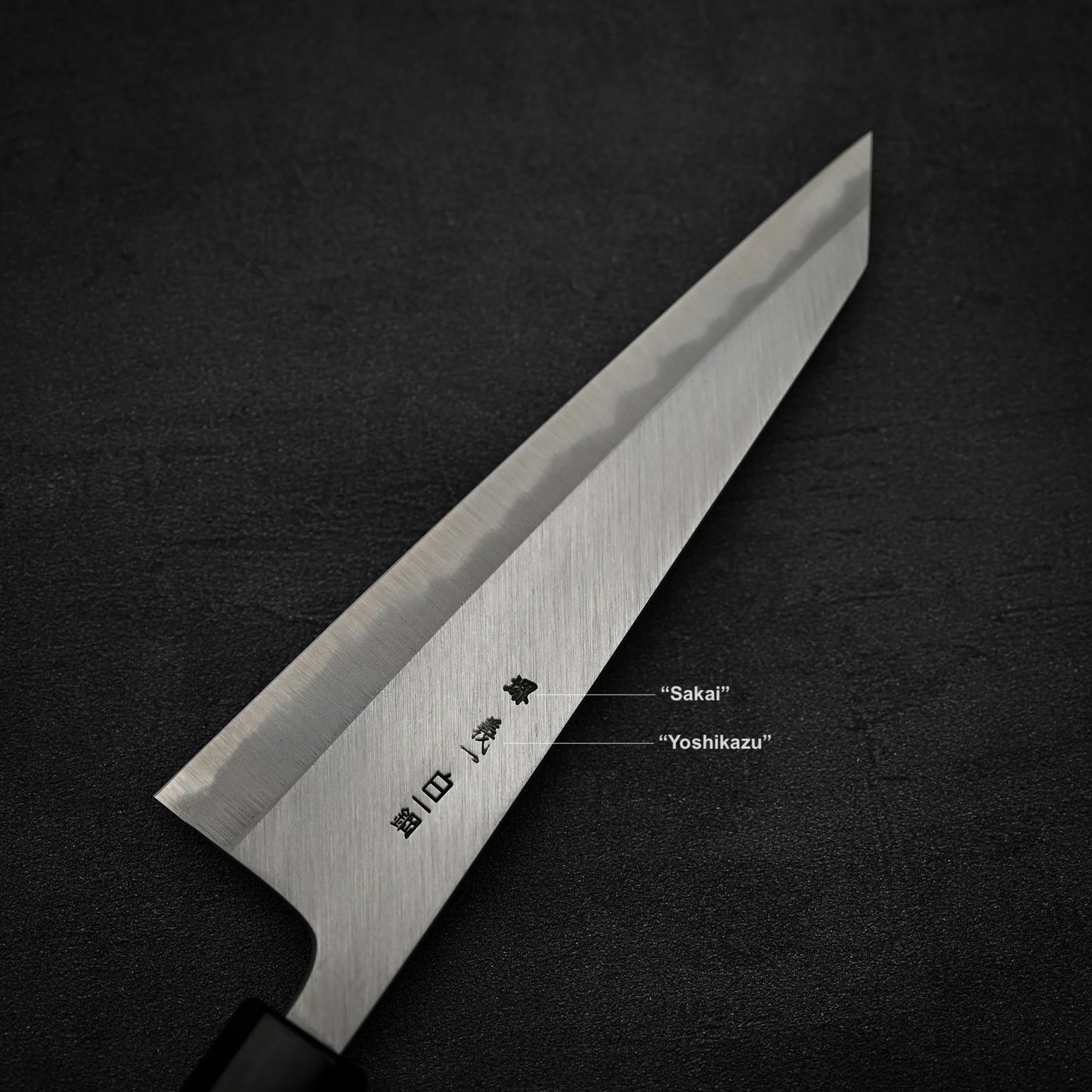 Close up view of the back blade of Yoshikazu Tanaka shirogami#1 double bevel honesuki knife showing kanji