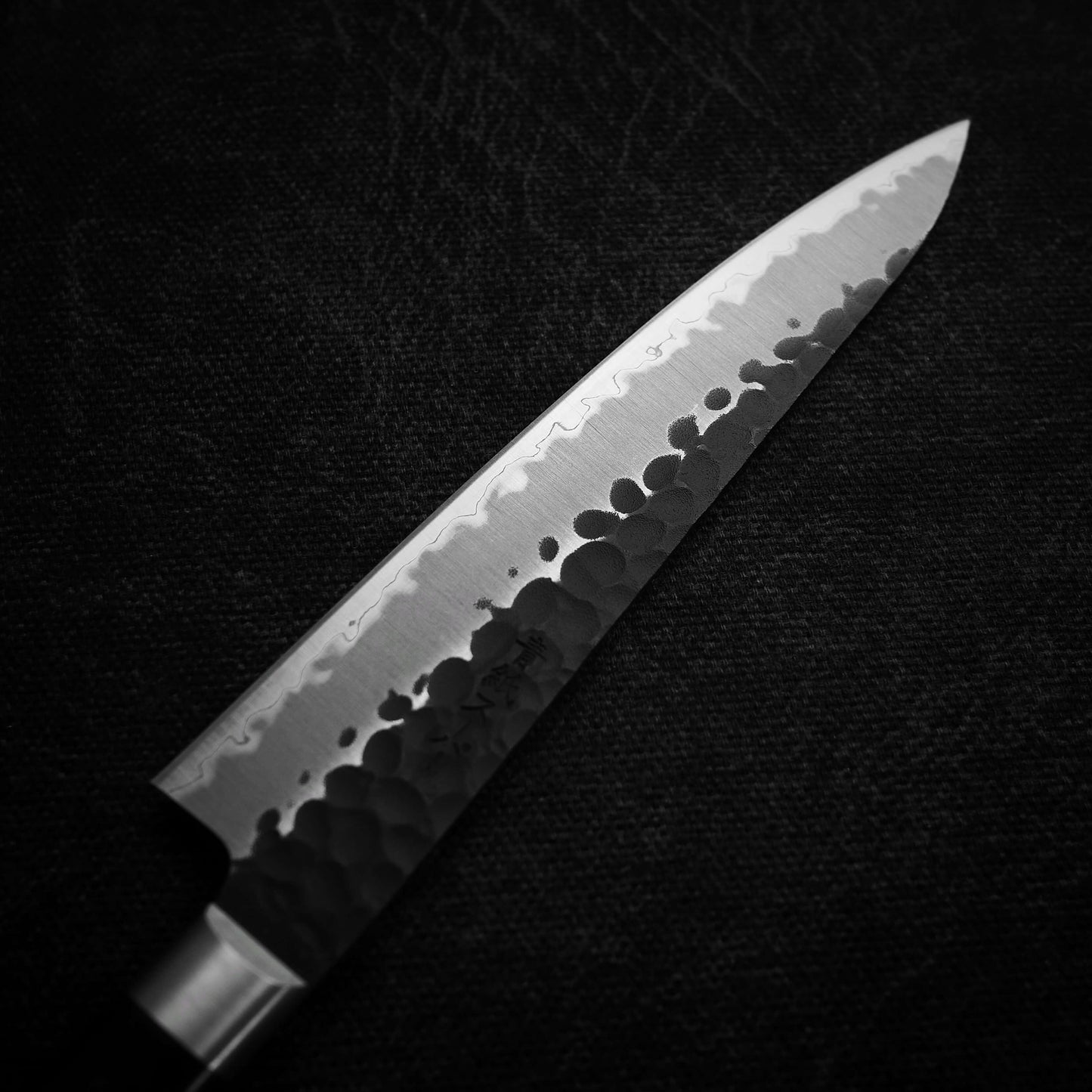 Top view of the blade of Ittosai Kotetsu tsuchime kurouchi aogami super petty knife. Image shows the left side of the knife