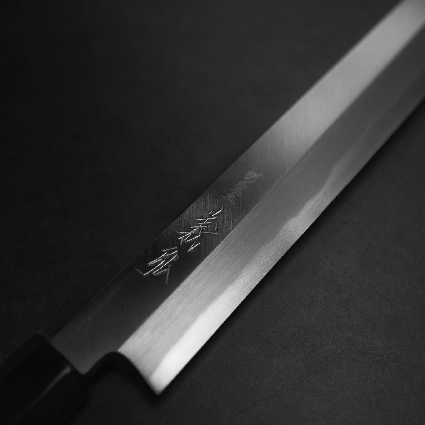 Close up view of Yoshihiro josaku shirogami #2 kiritsuke yanagiba 300mm. Image focuses on the kanji side.