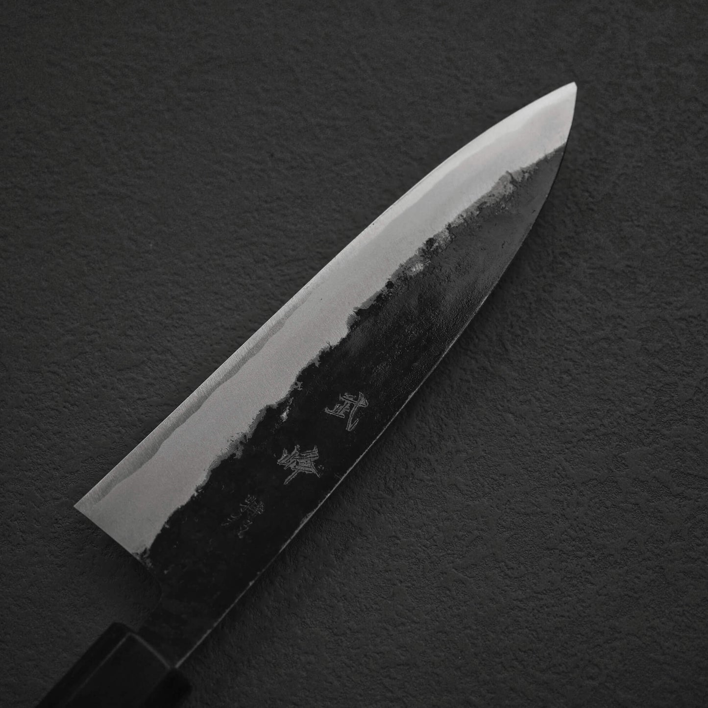 Top view of the blade of Murata Buho kurouchi aogami#1 funayuki knife. Image focuses on the left side of the blade.