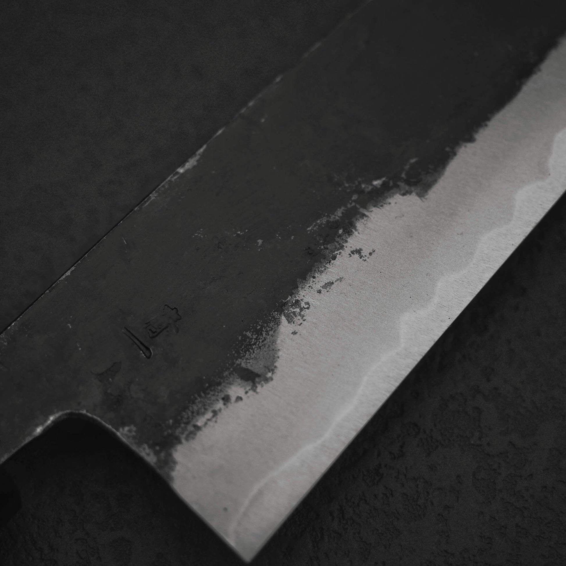 Close up view of Murata Buho kurouchi aogami#1 funayuki knife. Image focuses on the right side of the blade. 