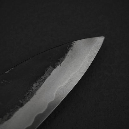 Close up view of Murata Buho kurouchi aogami#1 funayuki knife. Image focuses on the tip area of the right side of the blade.