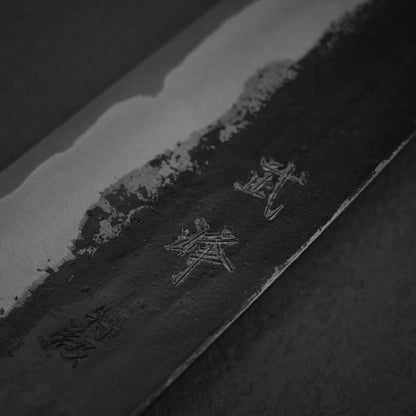 Close up view of the blade of Murata Buho kurouchi aogami#1 funayuki knife. Image focuses on the kanji side of the left side.