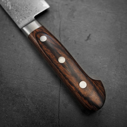 Close up view of Tsunehisa ZA18 damascus nakiri knife. Image focuses on the handle of the knife