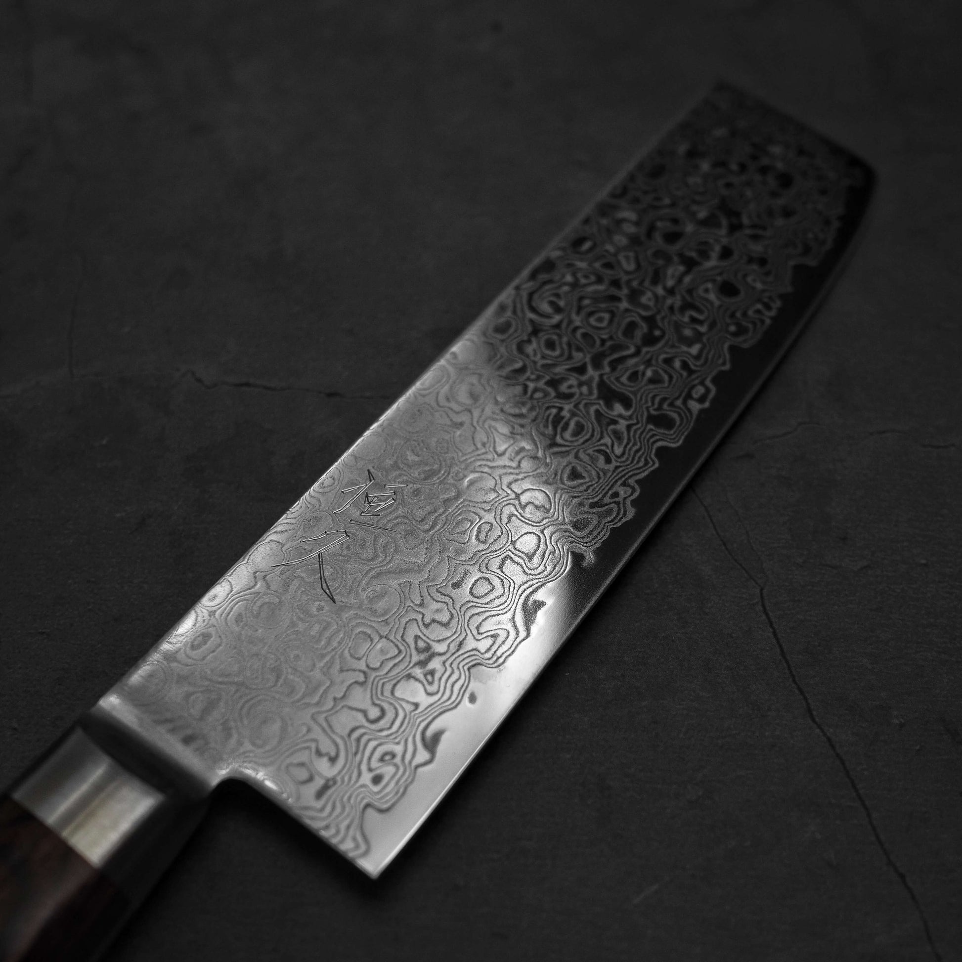 Angled view of Tsunehisa ZA18 damascus nakiri knife. Image shows the right side of the blade